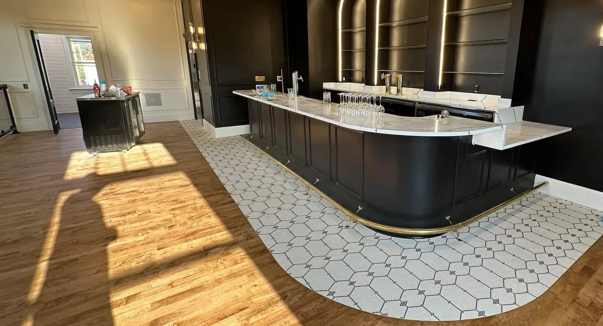 Luxury black bar with illuminated arches and marble countertop in modern lounge interior