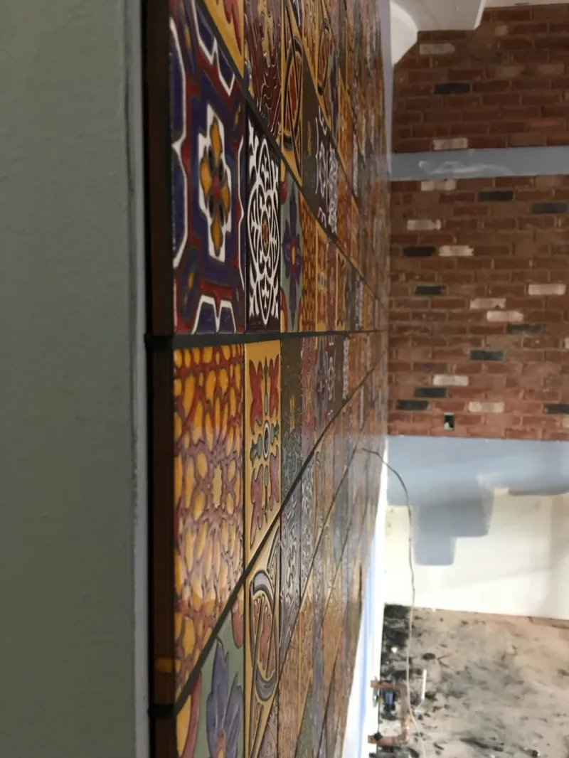 Colorful patterned tile backsplash with exposed brick wall in industrial loft kitchen