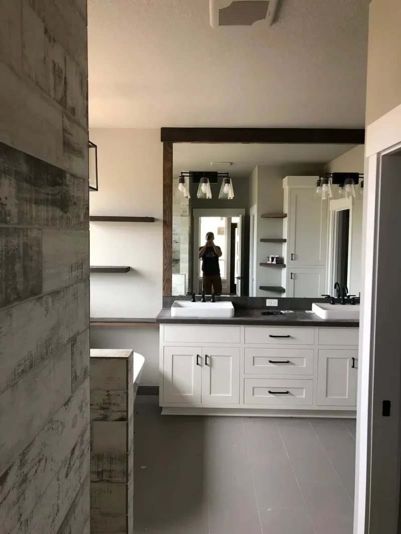 Modern farmhouse bathroom featuring double vanity, floating shelves, and rustic wood tile accents