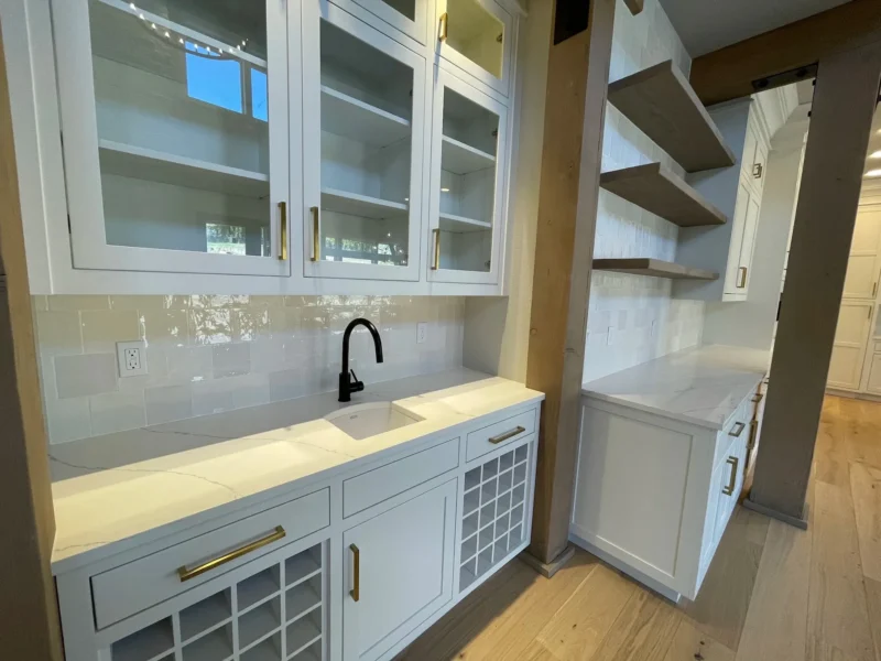image-asset-5 White wet bar cabinets with open shelving and black faucet
